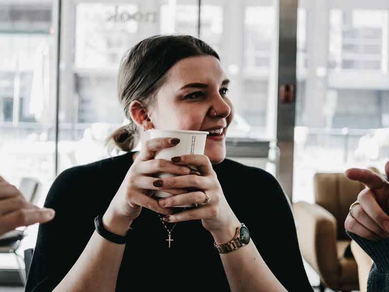 Young woman having coffee with friends.
